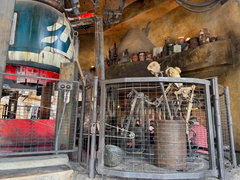 Freshly roasted meat-and-spice wraps on a heated rotating spit at Ronto Roasters in Star Wars: Galaxy's Edge at Disney's Hollywood Studios, the filling sizzling and caramelizing under the heat — a nod to the in-universe Spit-Roasted Rontos of Black Spire Outpost.
